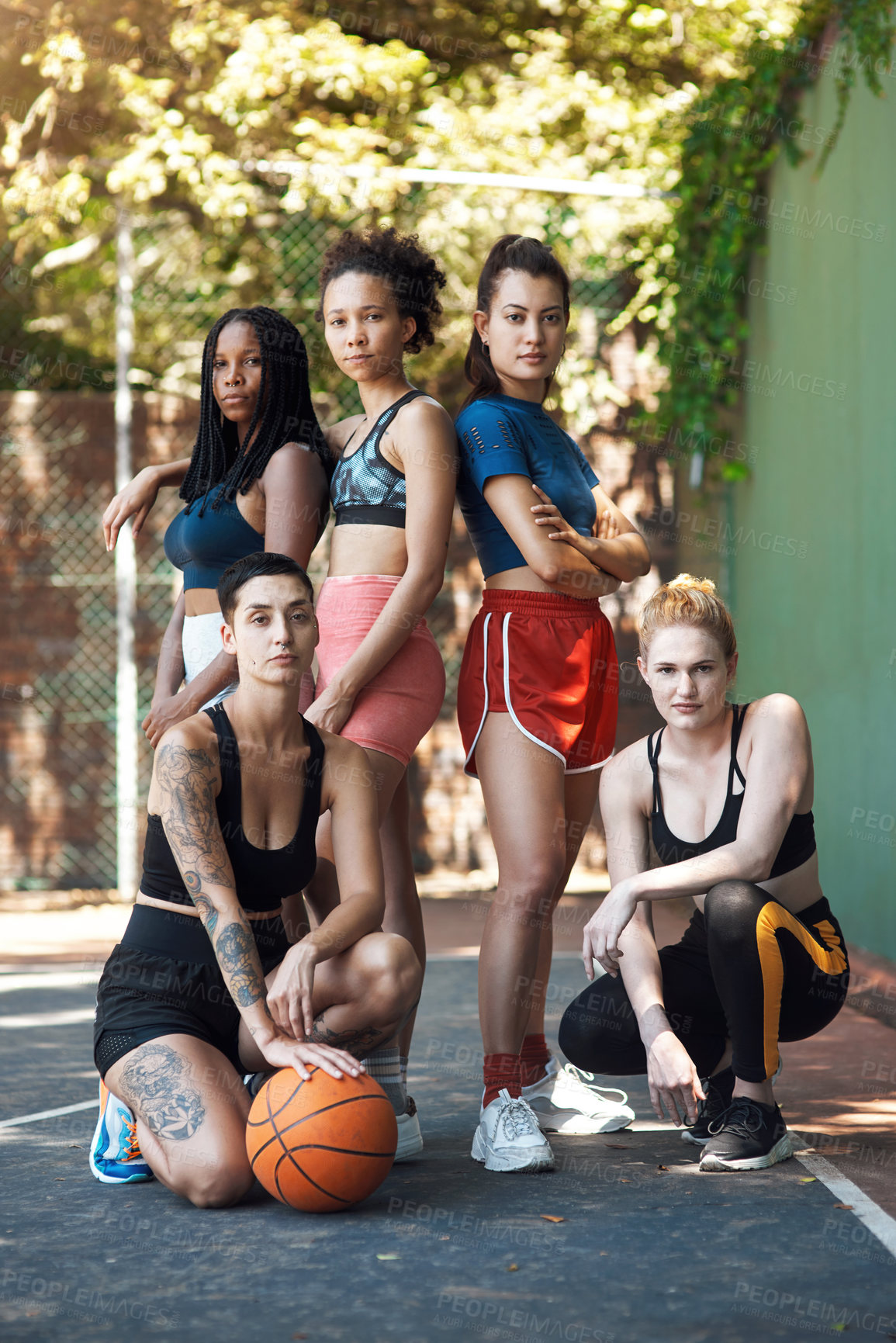 Buy stock photo Full length portrait of a group of attractive young female athletes posing together on the basketball court