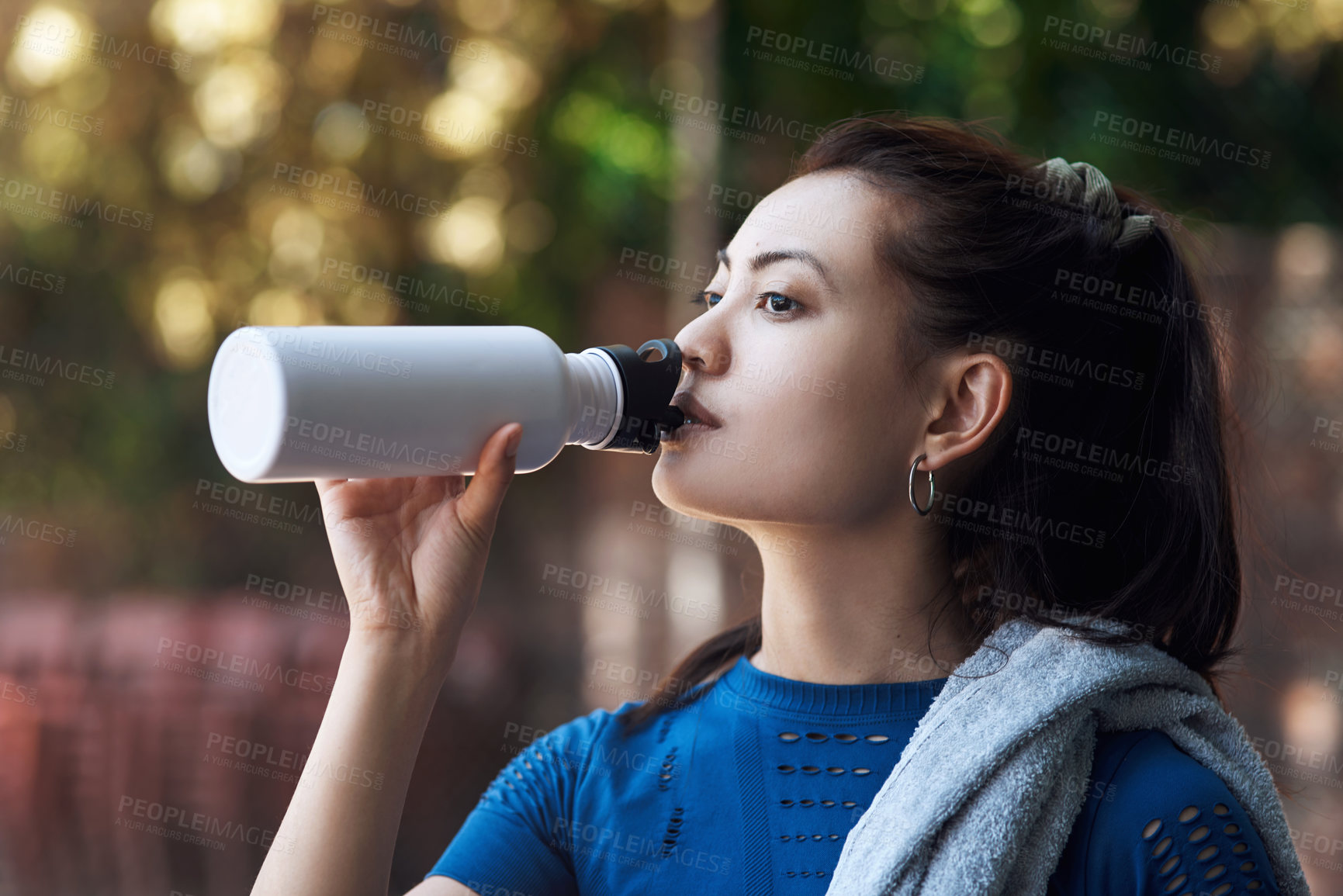 Buy stock photo Cropped shot of an attractive young female athlete drinking water while standing on the basketball court