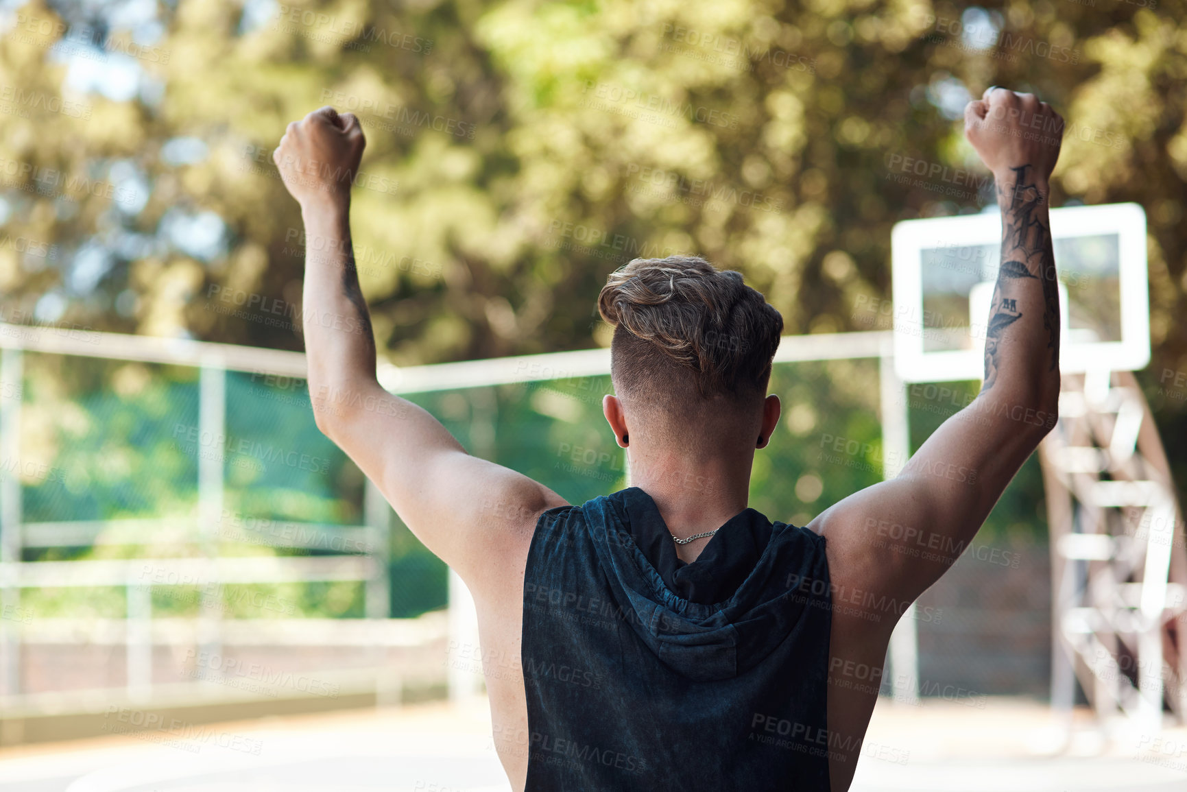 Buy stock photo Rearview shot of a sporty young man cheering on a sports court