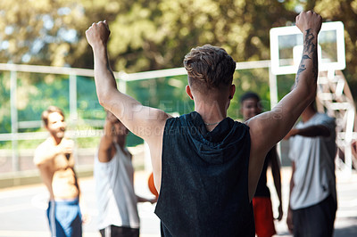 Buy stock photo Rearview shot of a sporty young man cheering with his friends on a sports court