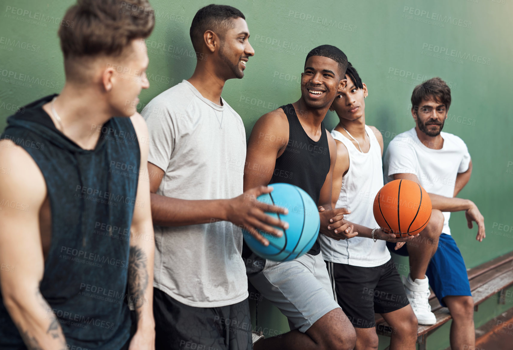 Buy stock photo Shot of a group of sporty young men hanging out on a basketball court