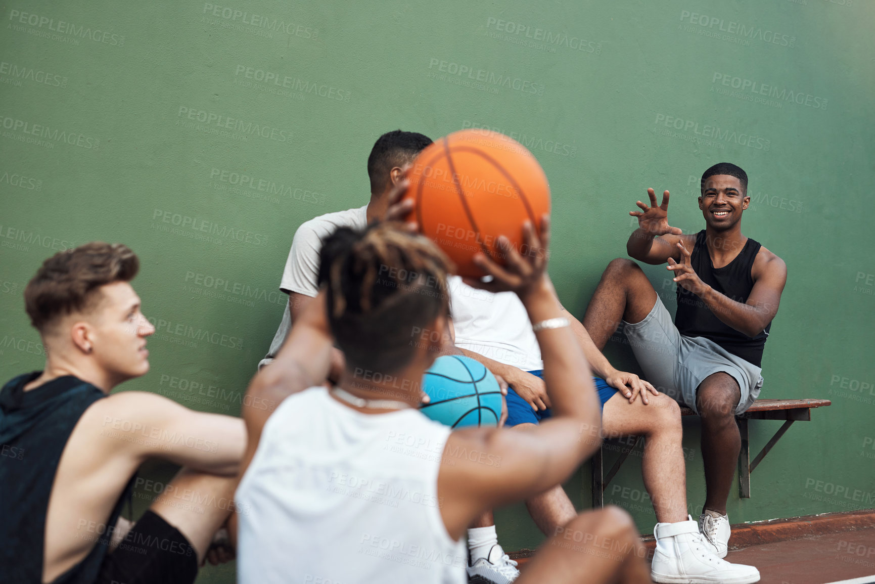 Buy stock photo Shot of a group of sporty young men hanging out on a basketball court