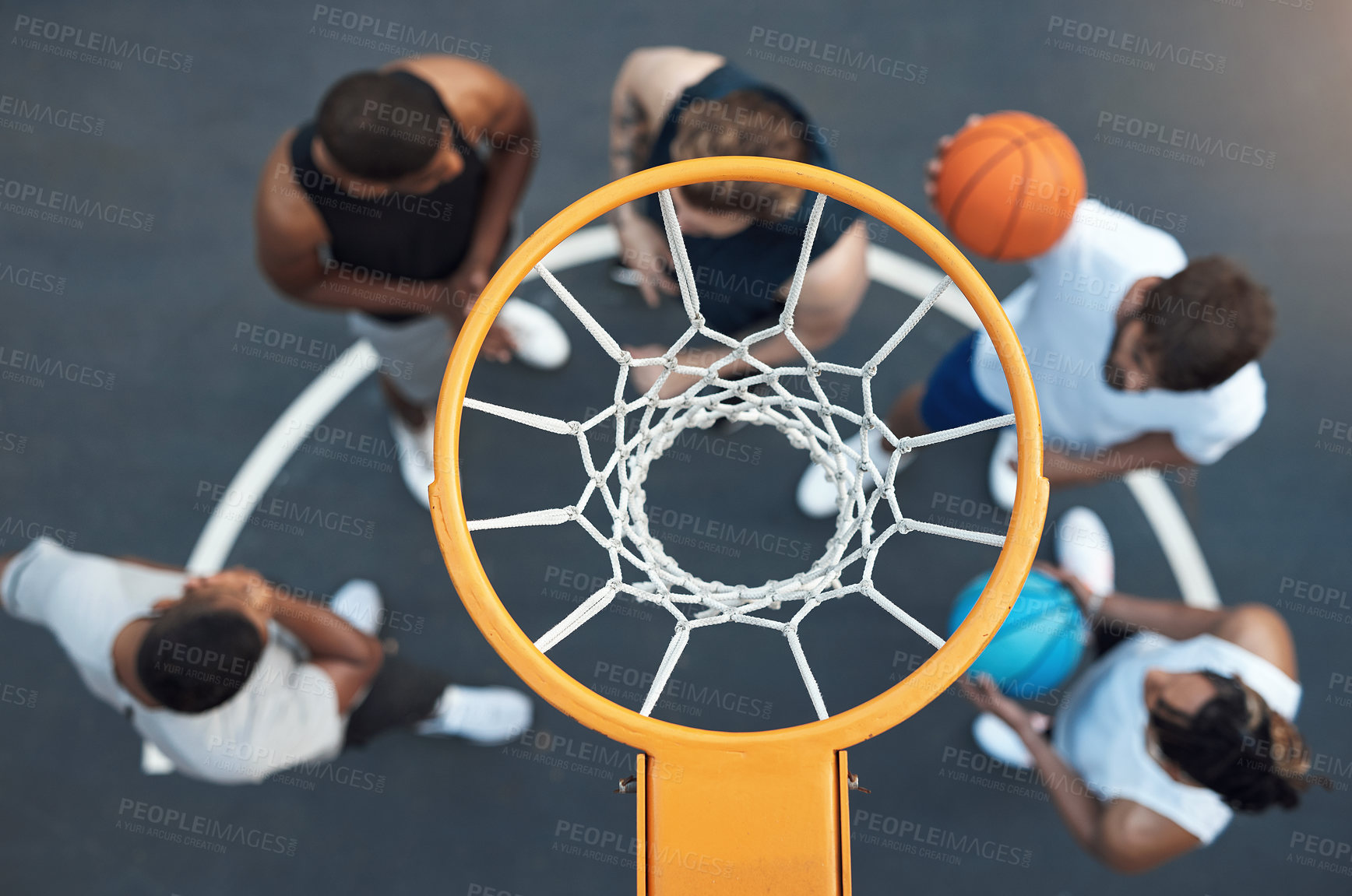 Buy stock photo High angle shot of a group of sporty young men hanging out on a basketball court