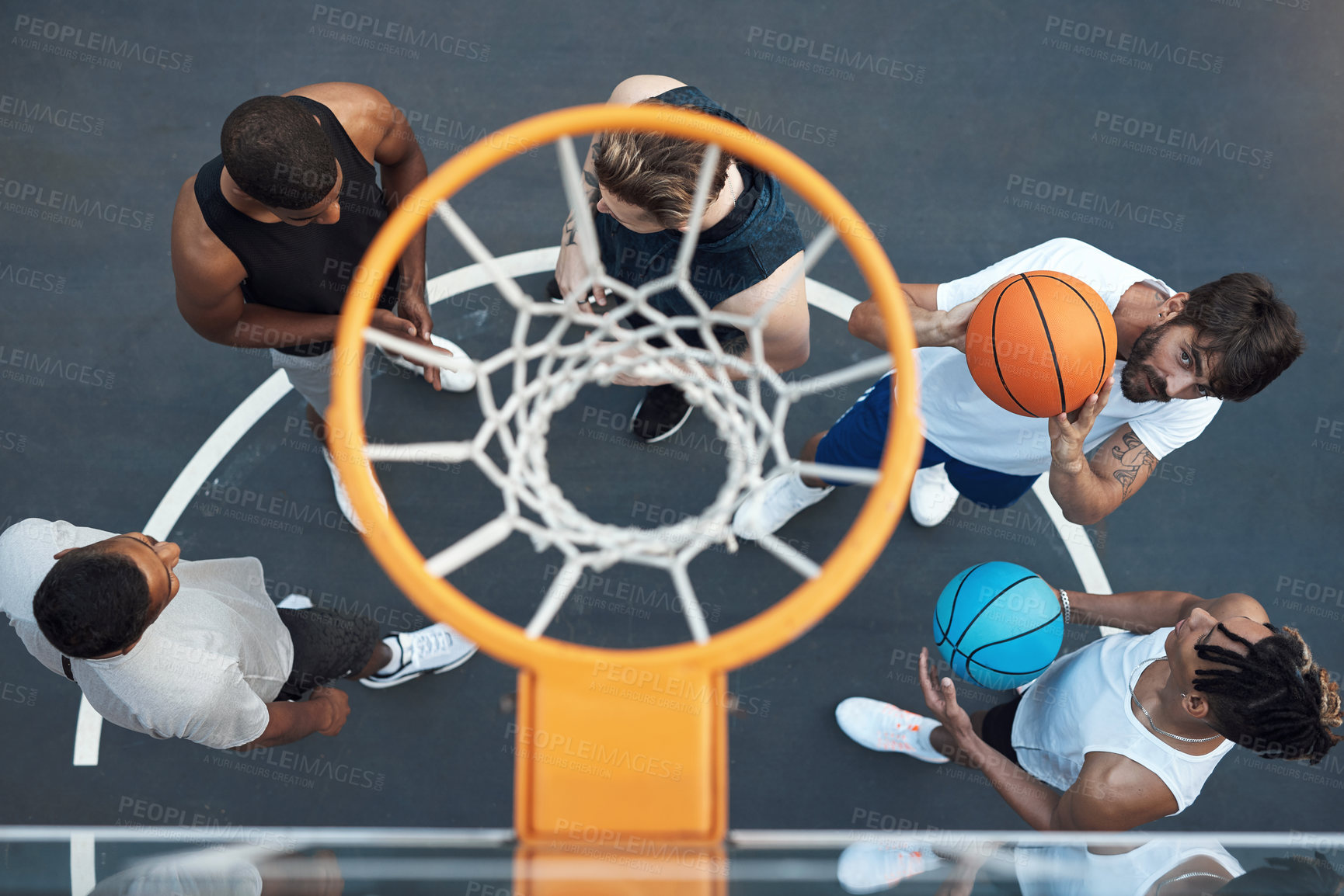Buy stock photo High angle shot of a group of sporty young men playing basketball on a sports court