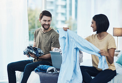 Buy stock photo Shot of a young couple doing laundry together at home