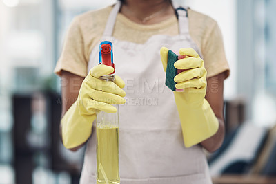 Buy stock photo Shot of an unrecognisable woman using rubber gloves and disinfectant to clean her home