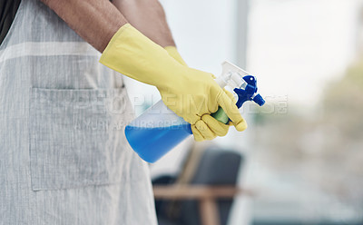 Buy stock photo Shot of an unrecognisable man using rubber gloves and disinfectant to clean his home