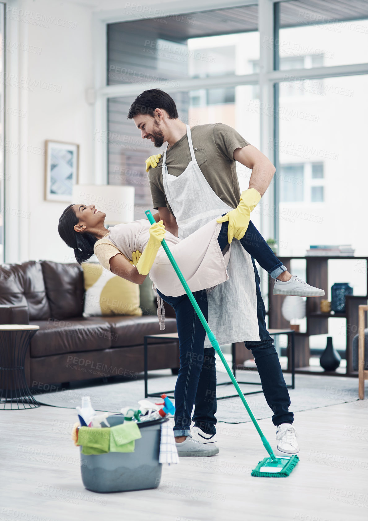 Buy stock photo Shot of a happy young couple dancing while mopping the floor at home