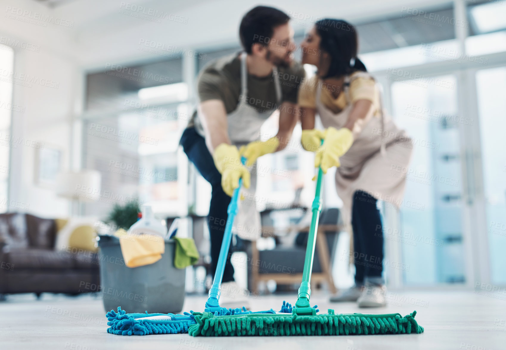Buy stock photo Shot of an affectionate young couple mopping the floor together at home