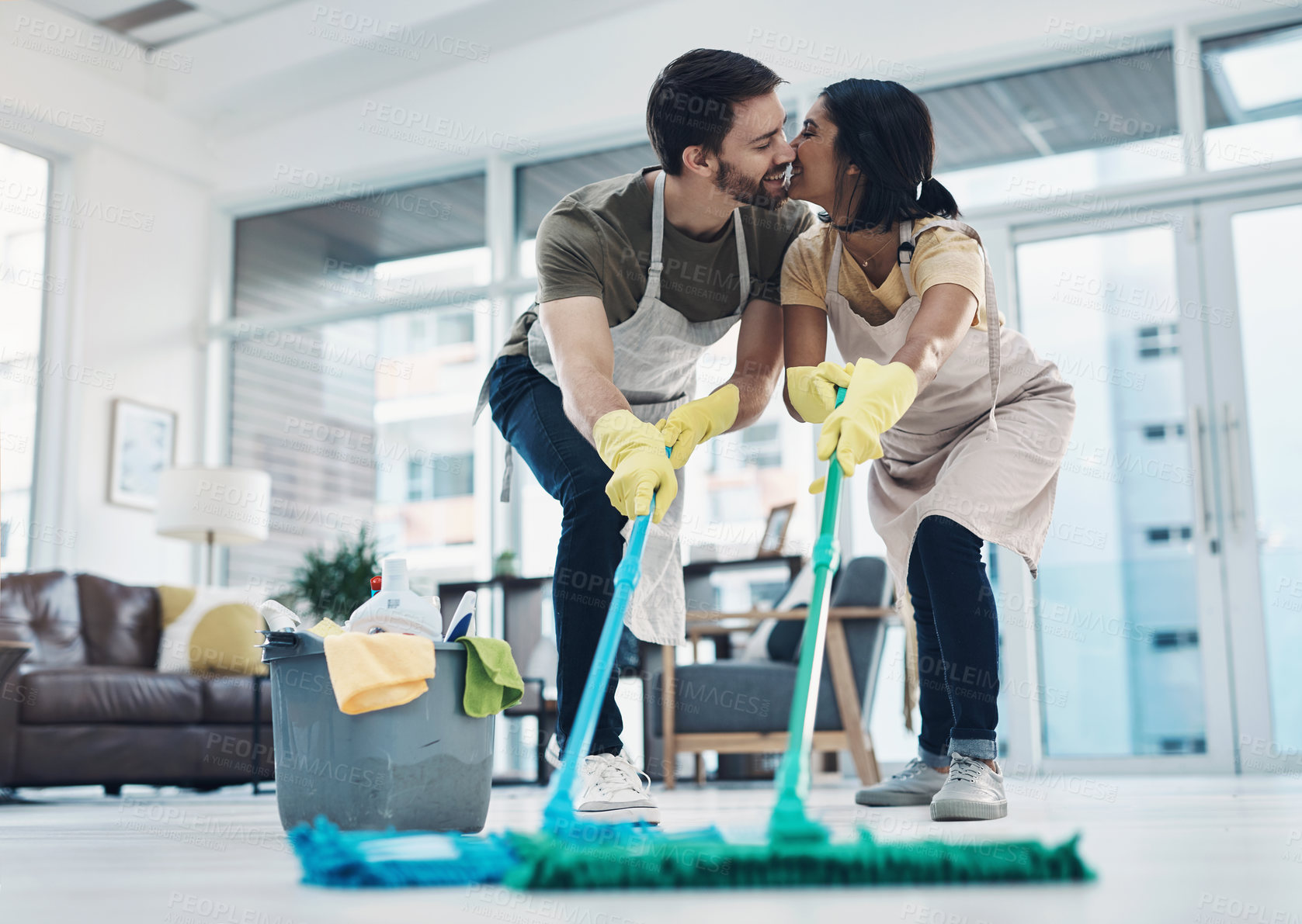 Buy stock photo Shot of an affectionate young couple mopping the floor together at home