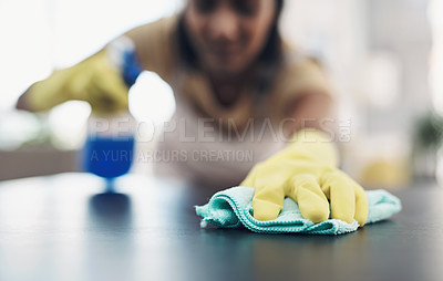 Buy stock photo Shot of a young woman disinfecting a table at home