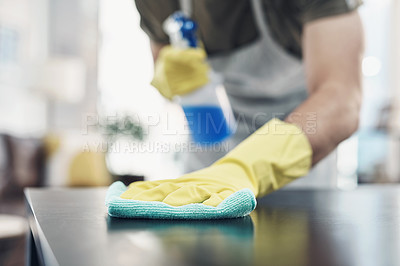 Buy stock photo Shot of an unrecognisable man disinfecting a table at home