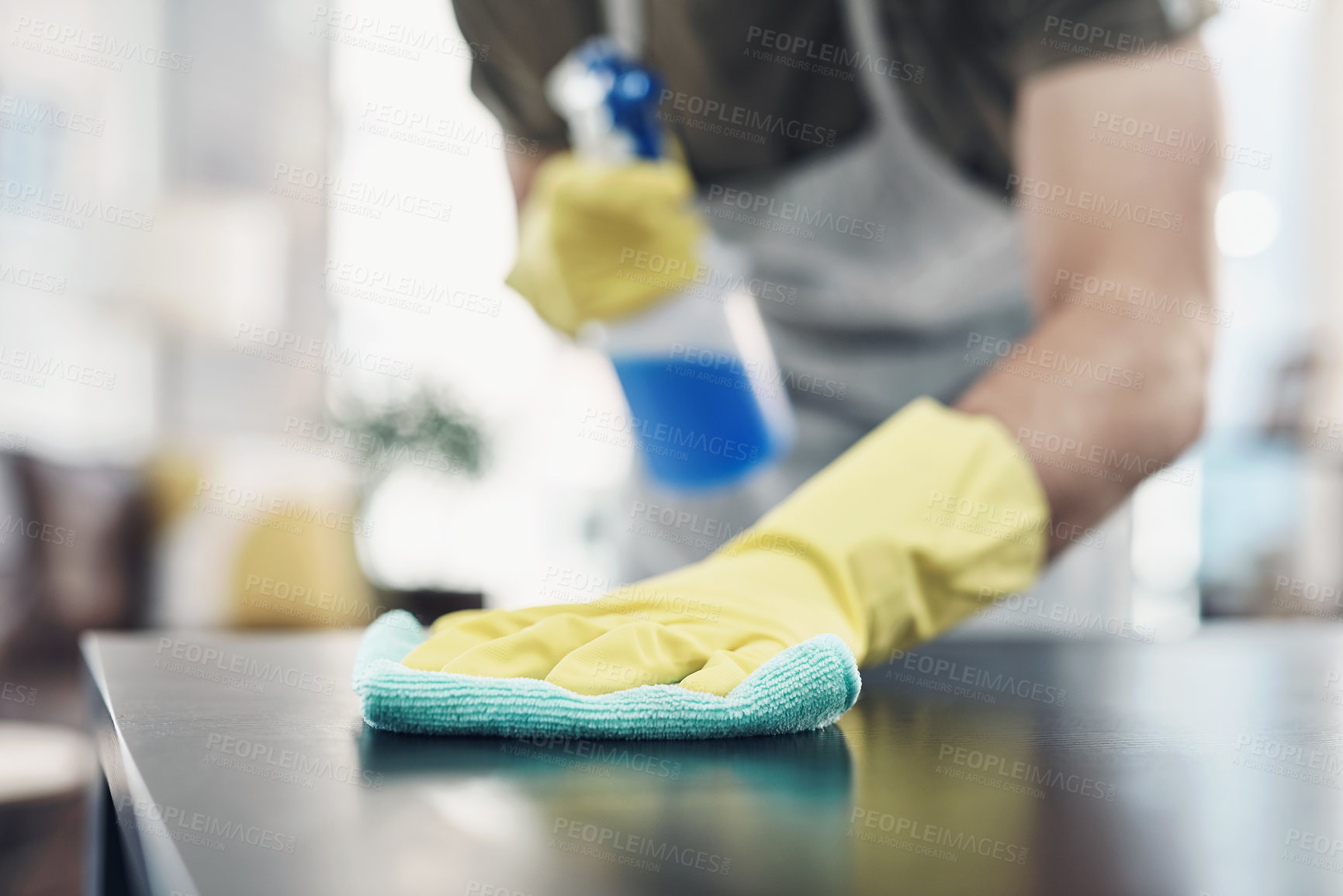 Buy stock photo Shot of an unrecognisable man disinfecting a table at home