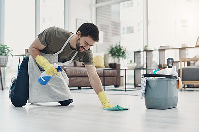Buy stock photo Shot of a young man wiping the floor at home