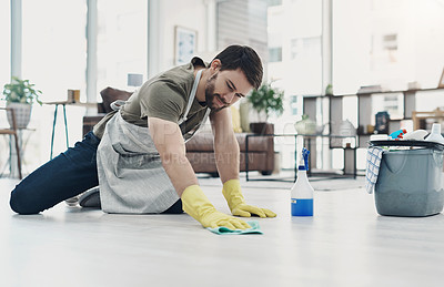 Buy stock photo Shot of a young man wiping the floor at home