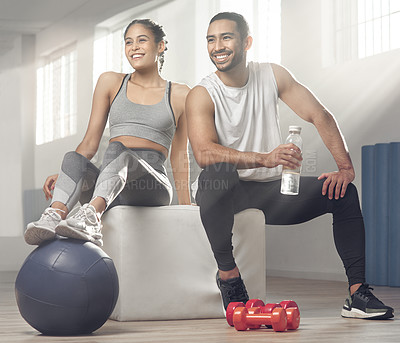 Buy stock photo Shot of two young athletes sitting together at the gym