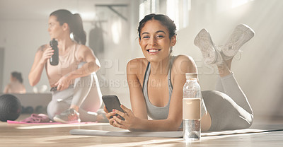 Buy stock photo Shot of two young female athletes taking a break while at the gym
