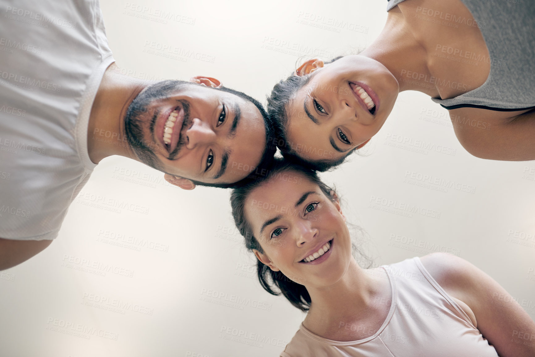 Buy stock photo Cropped shot of three young athletes standing together while looking down at the camera
