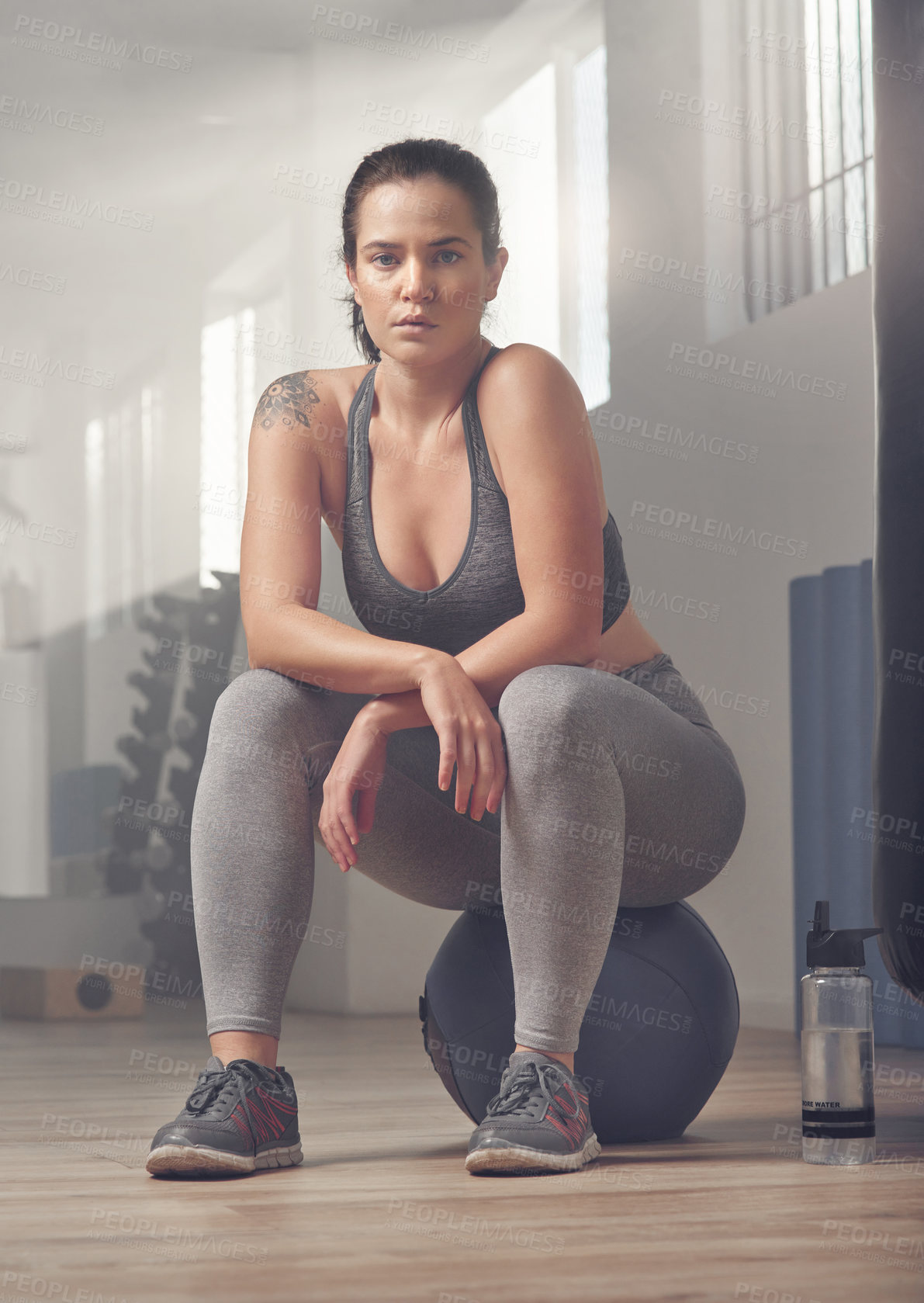 Buy stock photo Shot of a young female athlete sitting on a exercise ball in the gym