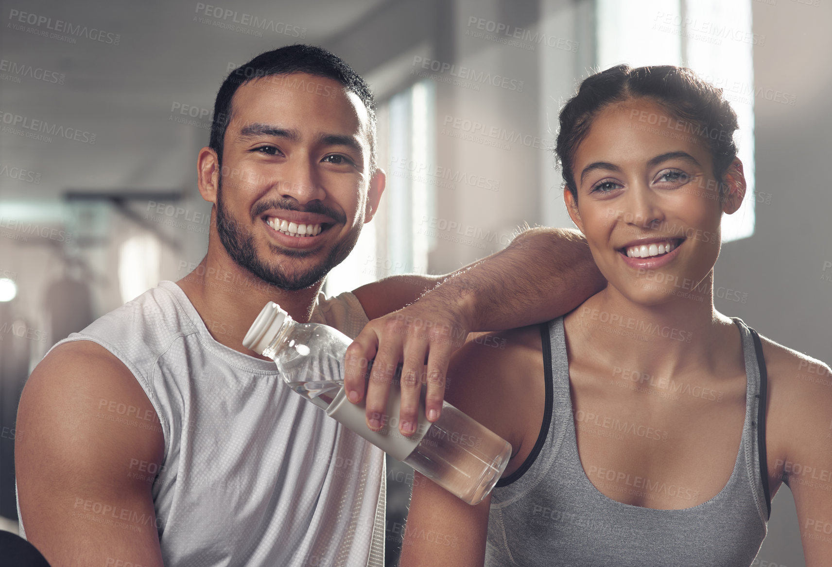 Buy stock photo Shot of two young athletes sitting together at the gym