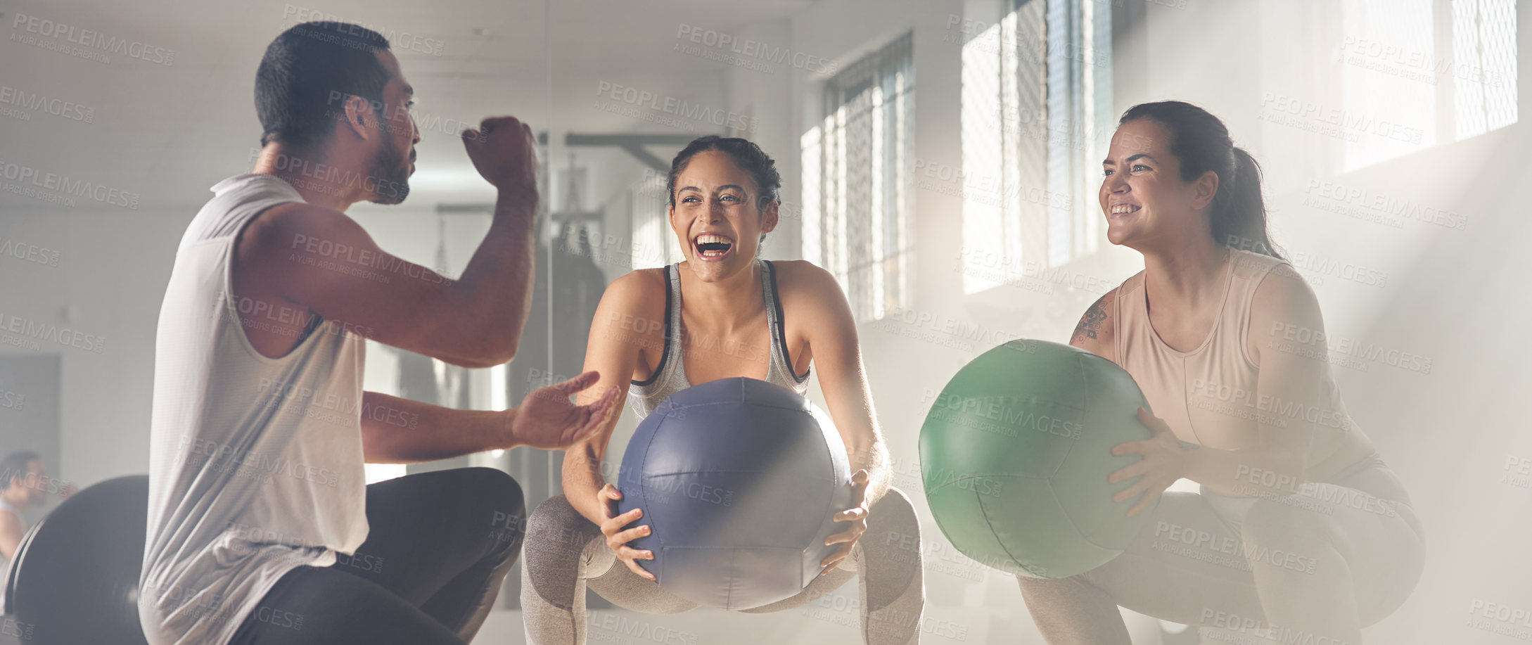 Buy stock photo Shot of two women using fitness balls while working out with their trainer