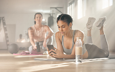 Buy stock photo Shot of a woman using her cellphone while on a break at the gym