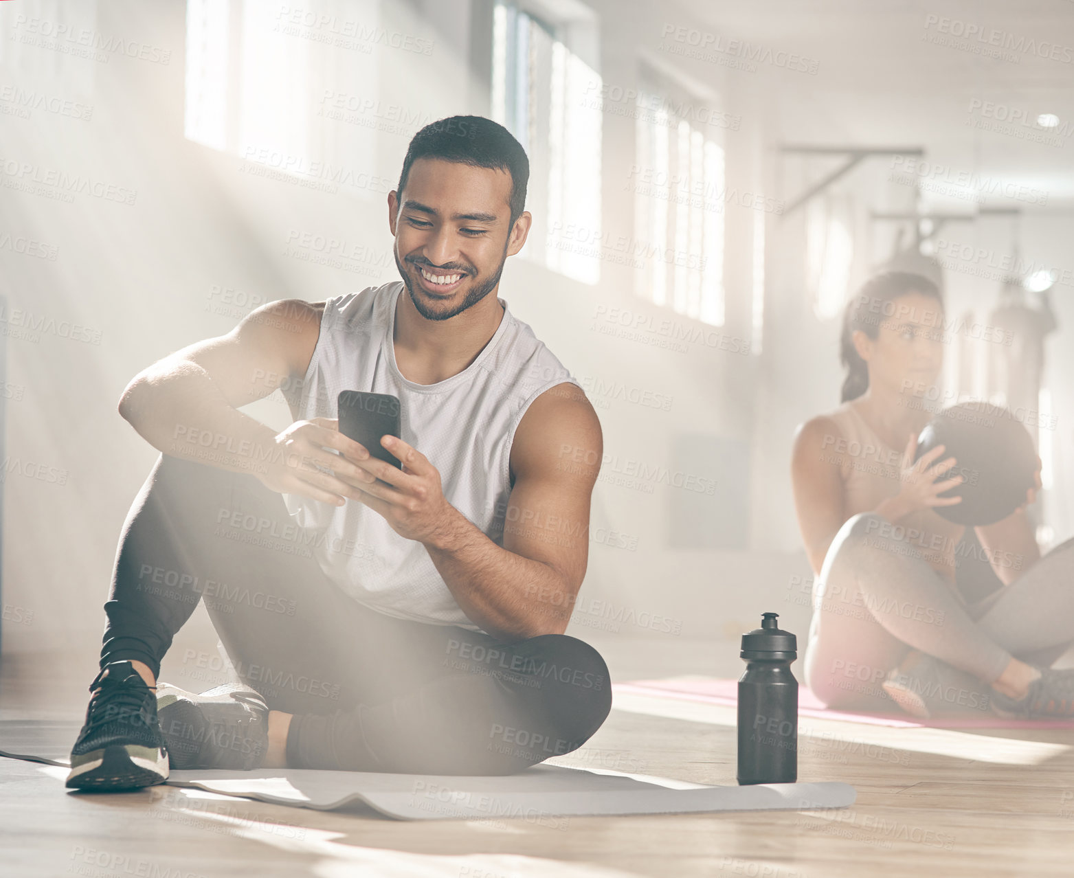 Buy stock photo Shot of a man using his cellphone while on a break at the gym