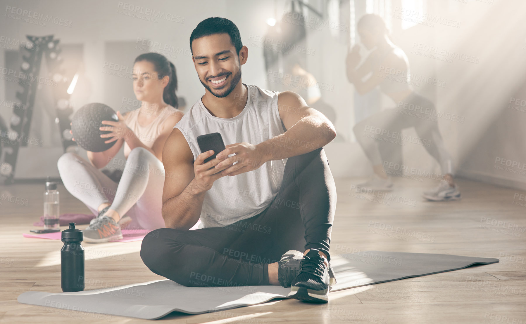 Buy stock photo Shot of a man using his cellphone while on a break at the gym