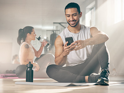 Buy stock photo Shot of a man using his cellphone while on a break at the gym