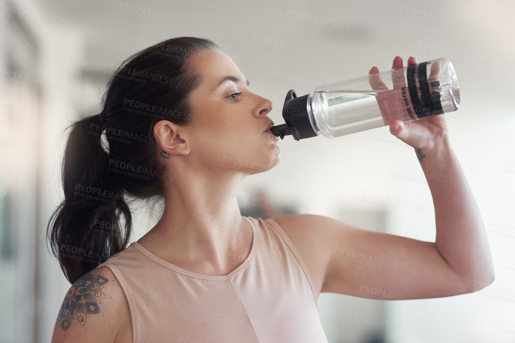 Buy stock photo Shot of a young athlete drink water while at the gym