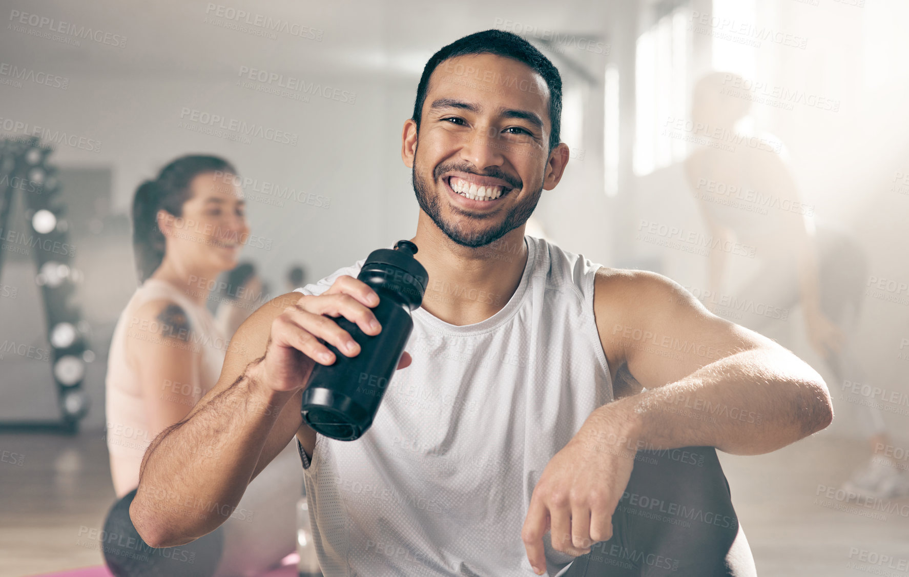 Buy stock photo Shot of a young male athlete drinking water while on a break at the gym