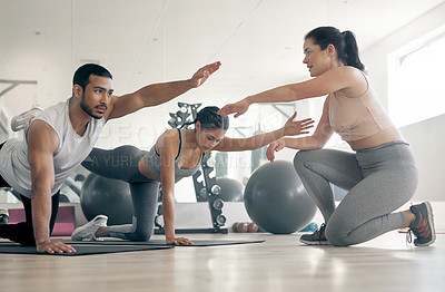 Buy stock photo Shot of two young athletes working out with their coach at the gym