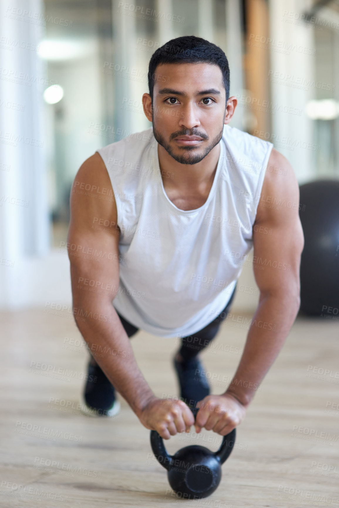 Buy stock photo Shot of a male athlete working out with a kettle bell