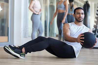 Buy stock photo Shot of a man using a medicine ball while working out at the gym