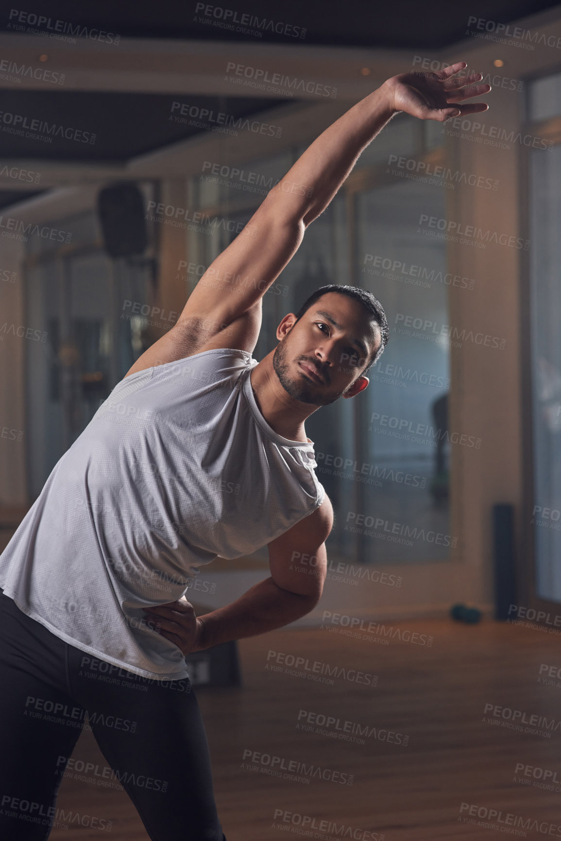Buy stock photo Cropped shot of a handsome young male athlete going through his warmup routine in the gym