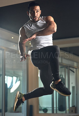 Buy stock photo Full length shot of a handsome young male athlete jumping during his workout in the gym