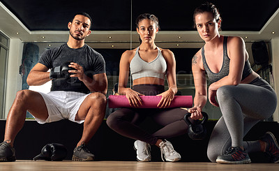 Buy stock photo Low angle portrait of three young athletes sitting in the gym