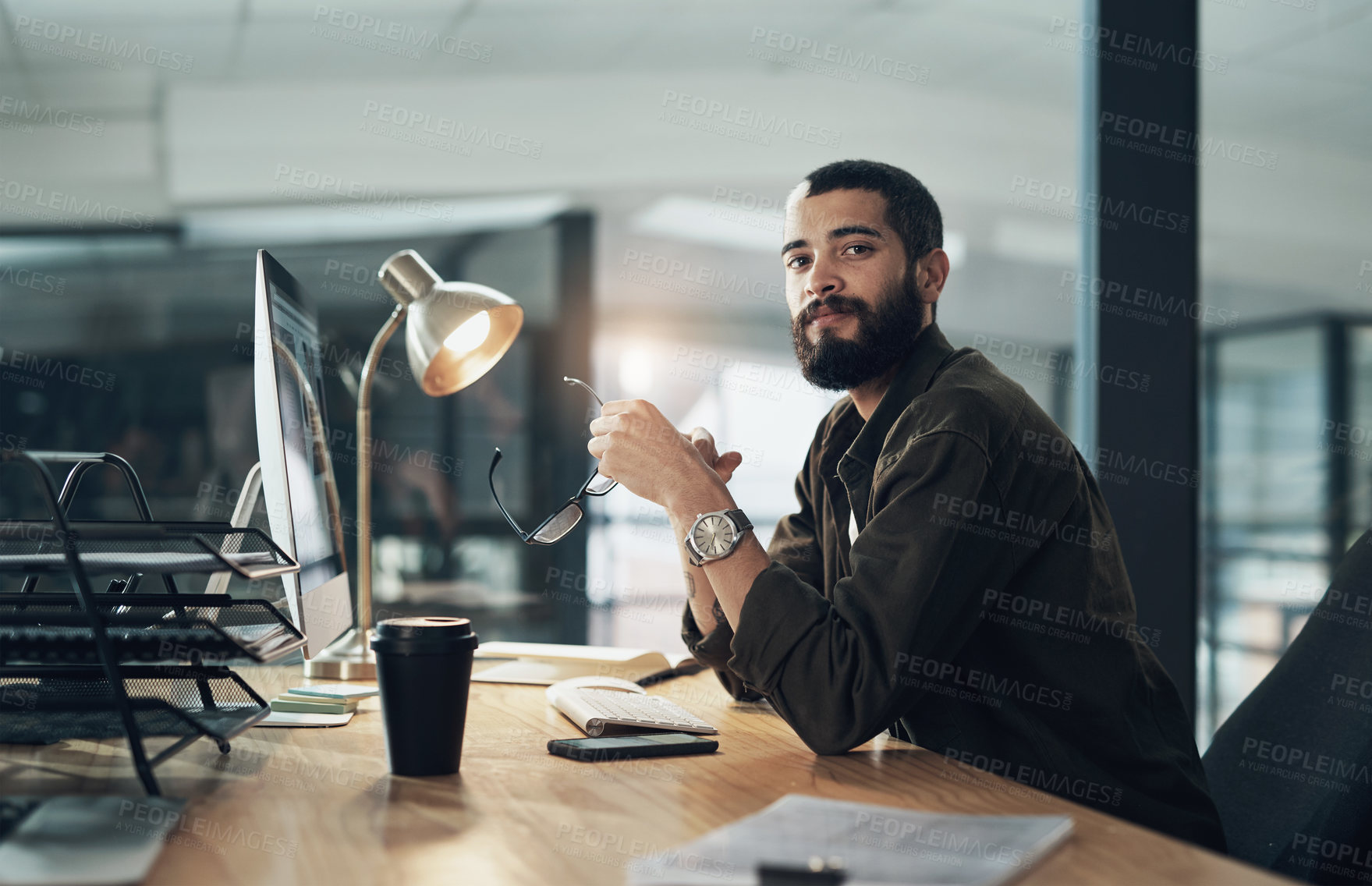 Buy stock photo Shot of a young businessman using a computer during a late night in a modern office