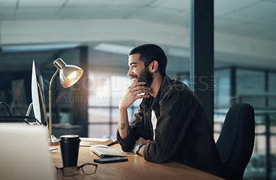 Buy stock photo Shot of a young businessman using a computer during a late night in a modern office