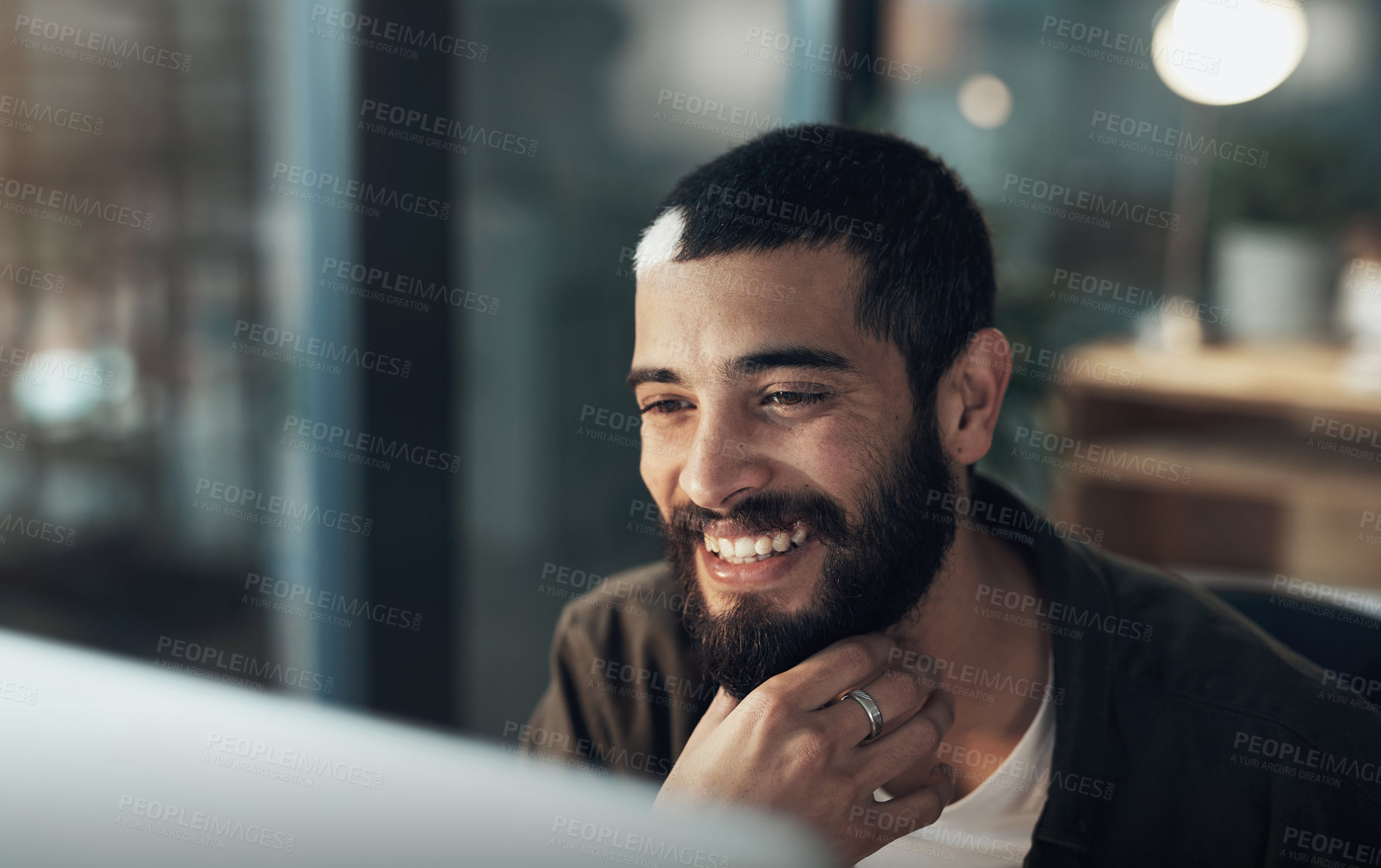 Buy stock photo Shot of a young businessman using a computer during a late night in a modern office