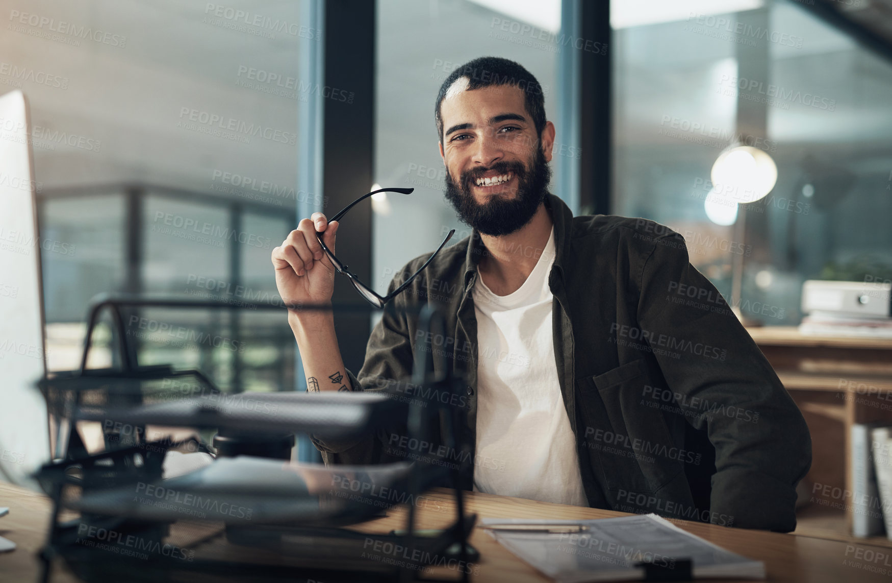 Buy stock photo Shot of a young businessman using a computer during a late night in a modern office