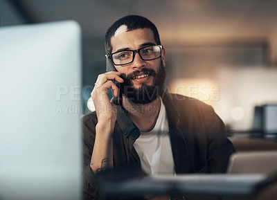 Buy stock photo Shot of a young businessman using a computer and smartphone during a late night in a modern office