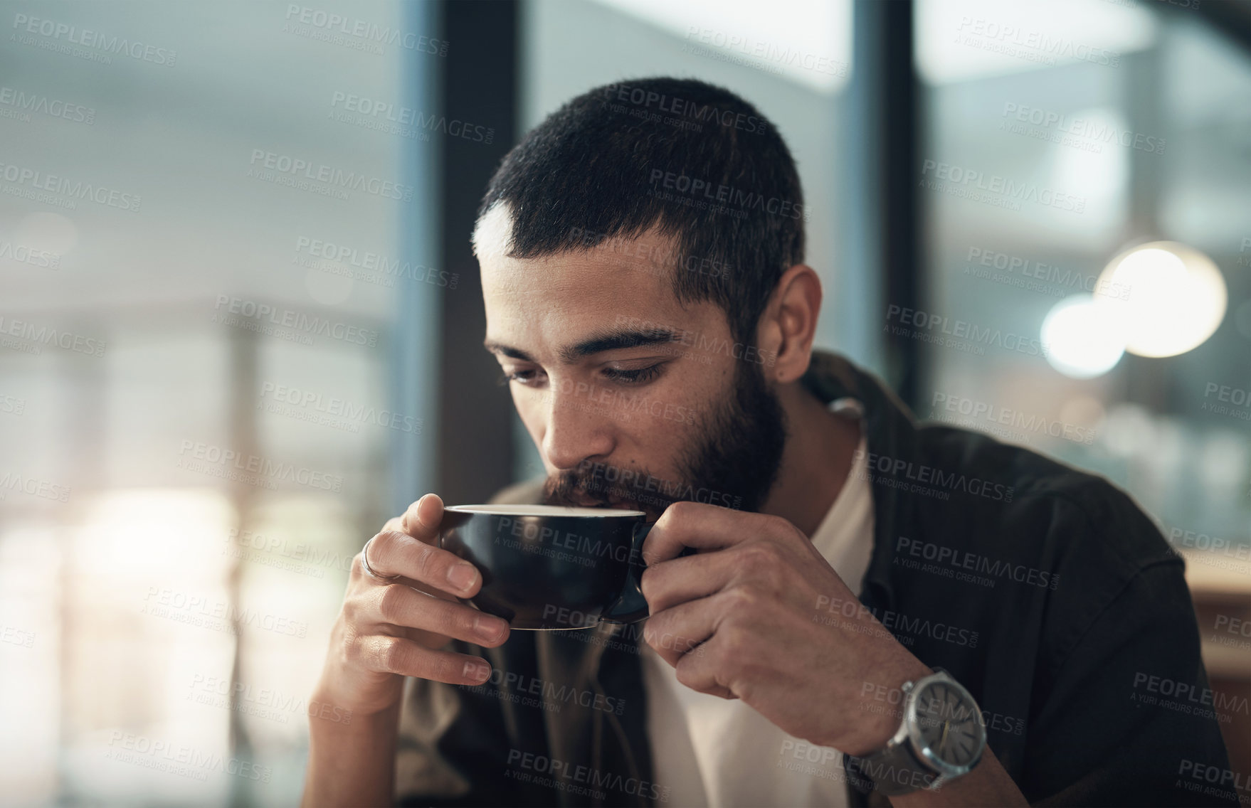 Buy stock photo Shot of a young businessman having a coffee break during a late night in a modern office