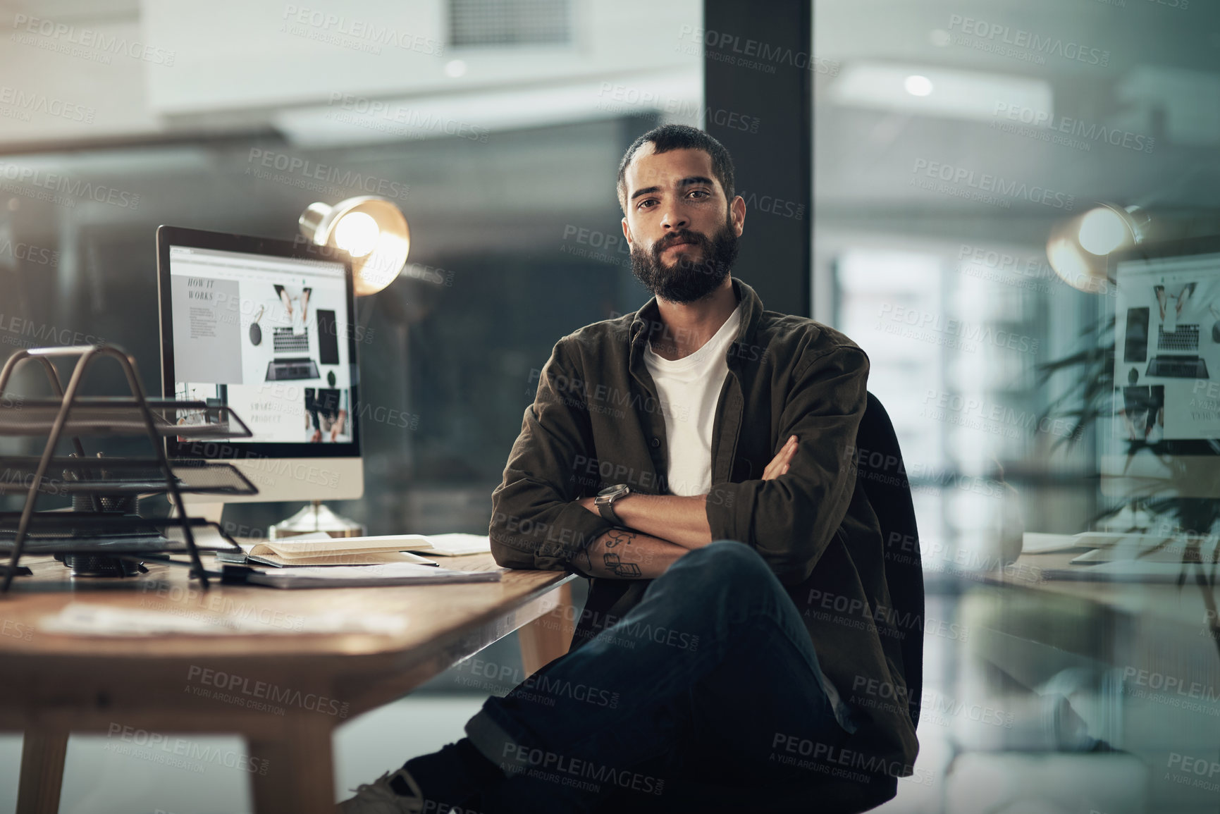 Buy stock photo Portrait of a confident young businessman working late at night in a modern office