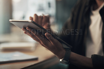 Buy stock photo Shot of an unrecognisable businessman using a digital tablet during a late night at work