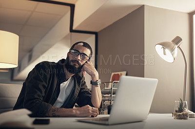Buy stock photo Shot of a young businessman looking uncertain while working late at night in a modern office
