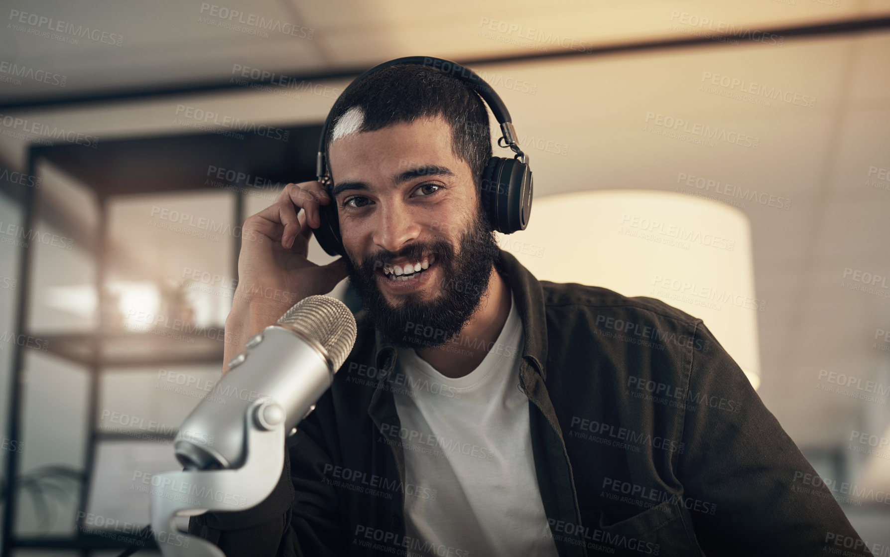 Buy stock photo Shot of a young man using a headset and microphone during a late night at work