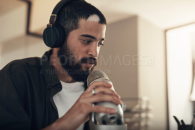 Buy stock photo Shot of a young man using a headset and microphone during a late night at work