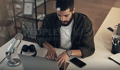 Buy stock photo Laptop, podcast and typing with man in office at night for upload to streaming site or website. Computer, microphone and update with employee at desk in workplace for video editing from above