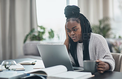 Buy stock photo Shot of a young woman using a laptop while working from home